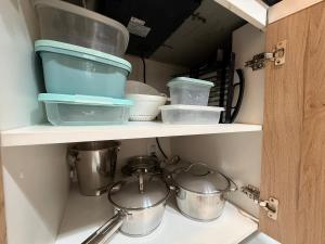 a shelf with pots and pans in a kitchen at Lovely Studio - GRU 1613 in Guarulhos +51 photos