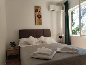 a bedroom with a bed with two towels on it at Apartments Knežić in Igrane