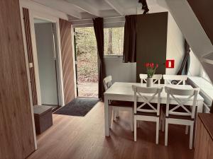 a dining room with a white table and chairs at Chalet AchiLou in Durbuy