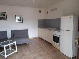 a kitchen with a white refrigerator and a table at chez Brigitte et Michel in Les Anses-dʼArlets