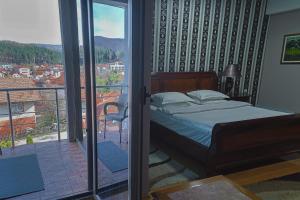 ein Schlafzimmer mit Bett und Balkon mit Aussicht in der Unterkunft Hotel Gold in Pljevlja