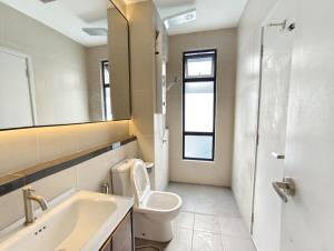 a bathroom with a toilet and a sink and a mirror at Mallow Semi-D homestay in Rawang