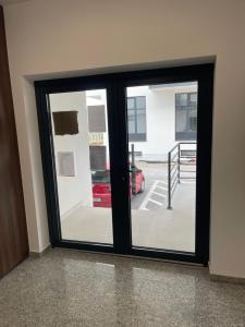 a sliding glass door with a red car outside at RelaxDream in Sînmartin
