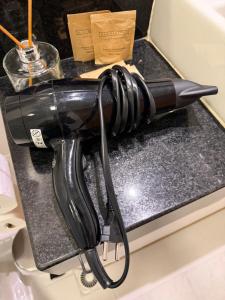 a black hair dryer sitting on top of a counter at Lovely Studio - GRU 1613 in Guarulhos