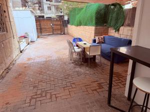 a patio with a table and chairs and a couch at ברזיליאנו - Braziliano in Eilat
