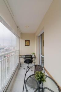 a balcony with a glass table and a chair at Lovely Studio - GRU 1613 in Guarulhos