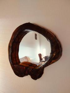 a mirror on a wall with a chair in a room at Small Stone Cottage in Virpazar +21 photos