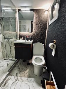 a bathroom with a toilet and a sink and a shower at Kjara's Nest in Neoi Epivates +17 photos