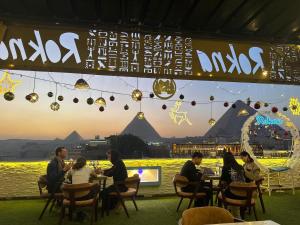 a group of people sitting at tables in a restaurant at Tua Pyramids View in Cairo