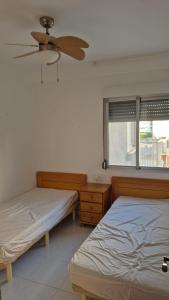 a bedroom with two beds and a ceiling fan at Pet Friendly Apartment Playa Tavernes in Tavernes de Valldigna
