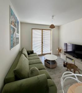 a living room with a green couch and a table at Wydmowa Ostoja in Żarnowska