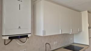 a kitchen with white cabinets and a sink at Pet Friendly Apartment Playa Tavernes in Tavernes de Valldigna