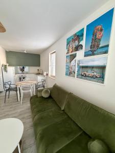 a living room with a green couch and a table at Wydmowa Ostoja in Żarnowska