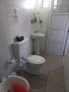 a white bathroom with a toilet and a sink at La Leonor in Formosa