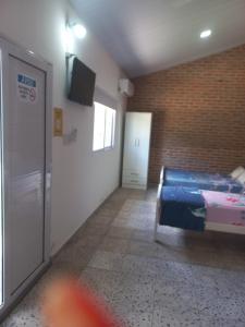 a room with a bed and a television in it at La Leonor in Formosa