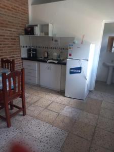 a kitchen with a white refrigerator and a table at La Leonor in Formosa