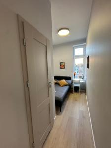 a living room with a couch and a window at MMRent Orange Room in Gdańsk