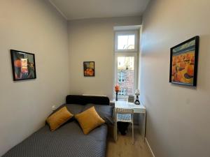 a small room with a bed and a desk at MMRent Orange Room in Gdańsk