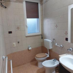a bathroom with a toilet and a sink and a window at Chiaro di Luna in Crispiano +7 photos