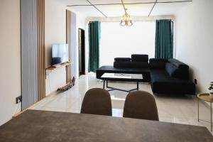 a living room with a black couch and a table at Lagrande CBD in Benoni