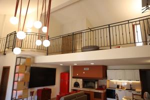 a living room with a staircase and a tv in a room at WANDERLUST OASI, COUNTRYSIDE APARTMENTS - Bardolino, Lago di Garda - Verona in Bardolino