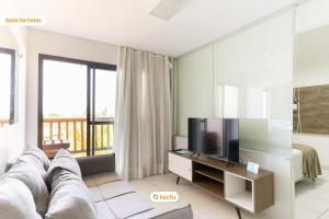 a living room with a couch and a tv at Equipped studio with sea view VG Sun Cumbuco in Paracumbuca
