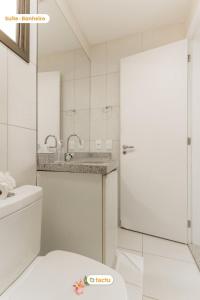 a bathroom with a white door and a sink at Equipped studio with sea view VG Sun Cumbuco in Paracumbuca +19 photos
