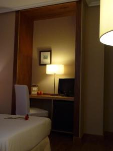 
a hotel room with a bed and a lamp at Hotel Picos de Europa in Arenas de Cabrales
