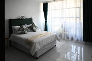 a bedroom with a bed and a large window at Lagrande CBD in Benoni