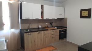 a kitchen with white cabinets and a sink and a stove at Appartamento - Plemmirio - Villa Maria Serena in Syracuse +26 photos
