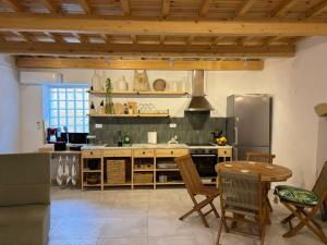 a kitchen with a stove and a table with chairs at Athina's Cozy Guest House in Kamisianá