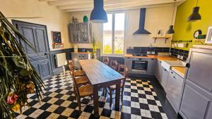 a kitchen with a table and chairs in it at L'Aube du Lac in Drosnay