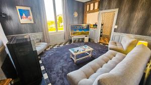 a living room with two couches and a tv at L'Aube du Lac in Drosnay