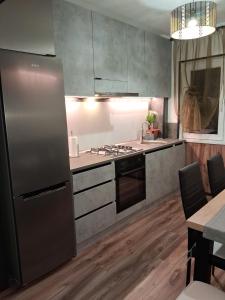 a kitchen with stainless steel appliances and wooden floors at Apartament Deea in Orşova