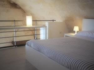 
a hotel room with a bed and a lamp at Ai Sassi di Pietro in Matera
