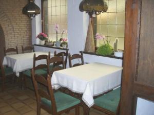 a dining room with two tables and chairs and flowers at Hotel Alte Münze in Gifhorn