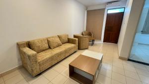 a living room with a couch and a table at Journy B Holiday Inn Ekala in Ekala