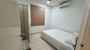 a small bedroom with a bed and a window at Journy B Holiday Inn Ekala in Ekala