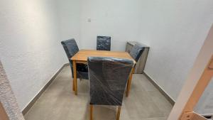 a wooden table and chairs in a room at Journy B Holiday Inn Ekala in Ekala