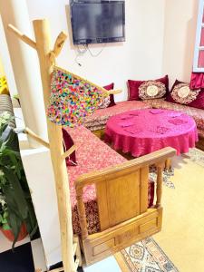 a living room with a couch and a table at maison avec deux chambres climatisées in Er Rachidia