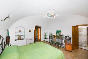 una camera con letto verde e ventilatore a soffitto di Casa Valentina a Positano