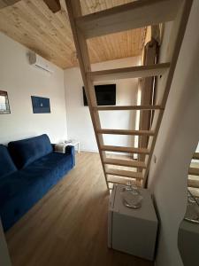 a living room with a blue couch and a staircase at Casa IRI - plaja Corbu in Corbu