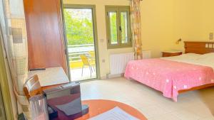 a bedroom with a bed and a table and a window at Klelia Hotel in Monemvasia