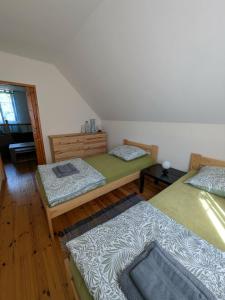 a room with three beds in a room at Gospodarstwo agroturystyczne nad jeziorem wśród lasów in Lipnica