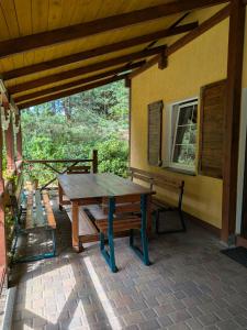 a wooden table and benches on a patio at Gospodarstwo agroturystyczne nad jeziorem wśród lasów in Lipnica