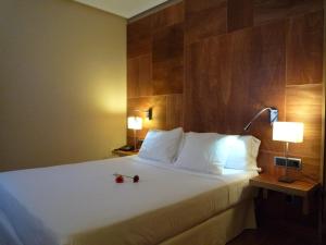 a hotel room with a bed with two red roses on it at Hotel Picos de Europa in Arenas de Cabrales