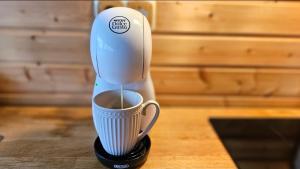 a coffee maker is pouring coffee into a cup at Pond View Cabin in Būda +18 photos