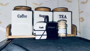 a wooden shelf with several containers of tea and a light bulb at ZulynHomes in Kisumu
