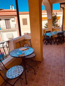a patio with tables and chairs on a balcony at perla house in Valledoria +9 photos