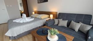 a living room with a couch and a blue couch and a table at Umberto Apartamenty Dwupoziomowe Dąbki in Dąbki +12 photos